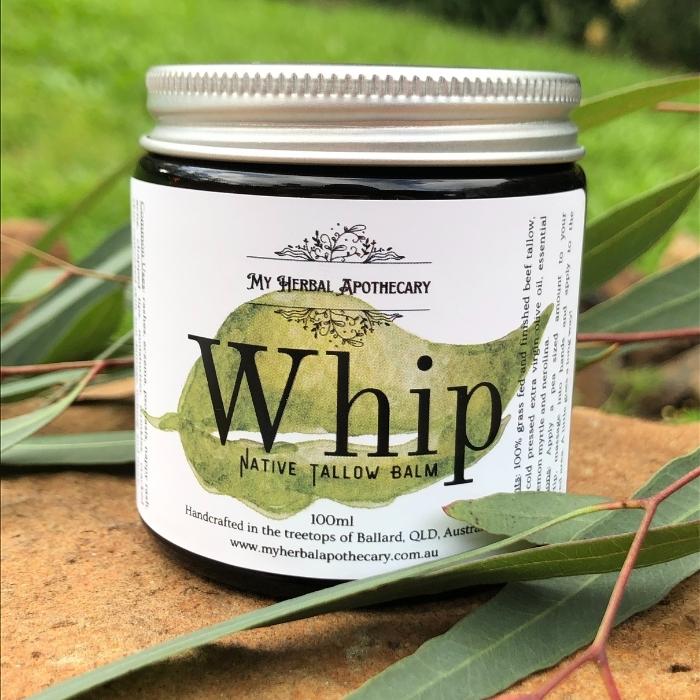 A jar of Whip Native Tallow Balm sits on a sandstone block with a green background and a eucalyptus leaf for decoration.