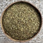 Organic dried peppermint leaves in a coconut bowl