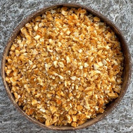 Organic sweet orange peel dried in a coconut bowl on a stone background.
