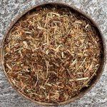 Organic St John’s Wort dried herb sitting in a coconut bowl on a stone background.